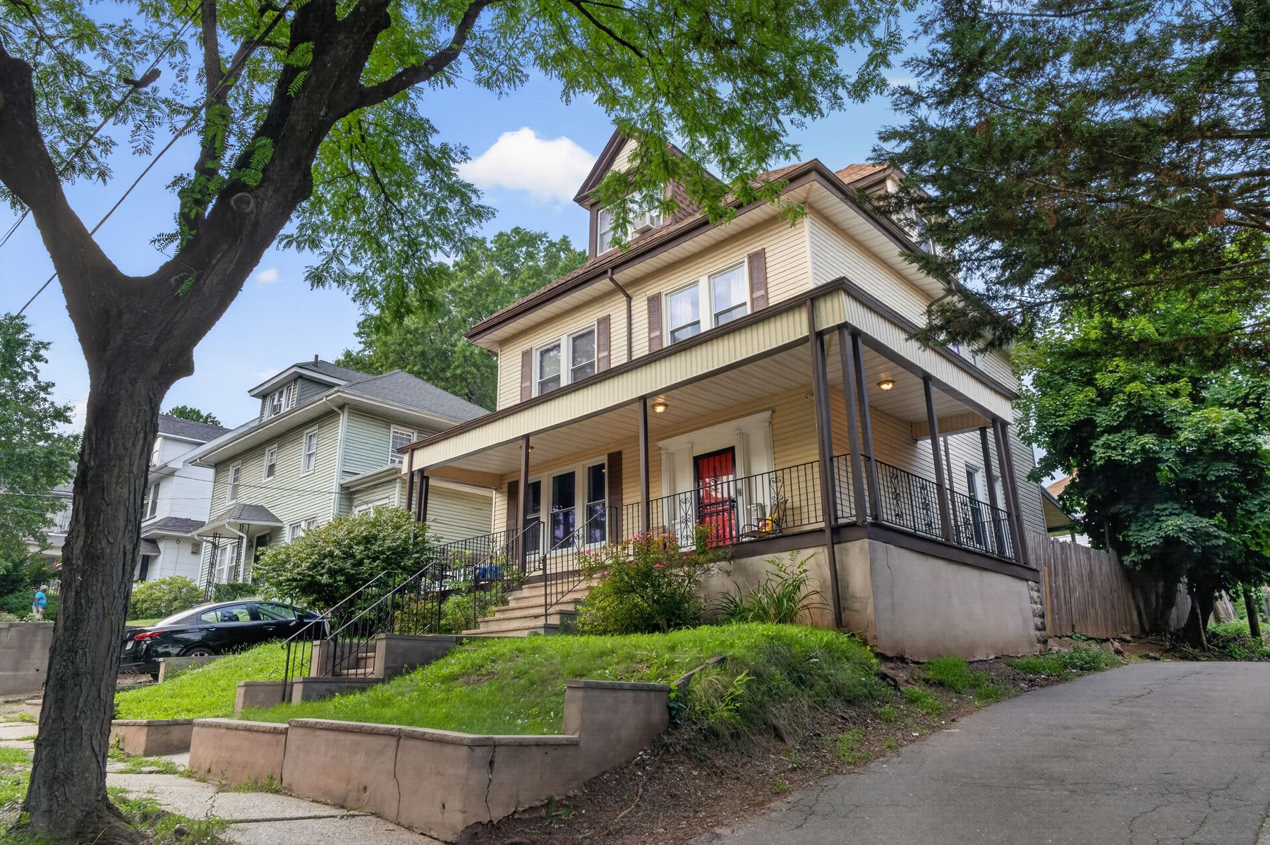 A Newark-area home from the street — wraparound porch, mature trees, and a quiet residential block